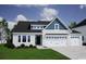 Charming two-story home featuring a three-car garage, manicured lawn, and inviting curb appeal at 265 Mayflower Dr., Calabash, NC 28467