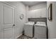 Convenient laundry room featuring a washer, dryer, and built-in storage cabinets at 265 Mayflower Dr., Calabash, NC 28467