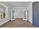 Versatile room with neutral walls, wood-look tile flooring, double french doors, bright window, and a sliding barn door at 2825 Stellar Loop, Myrtle Beach, SC 29577