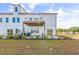 A multi-story white townhouse features a deck, patio and lush green landscaping at 305 Lineback Pl. # 33, Longs, SC 29568