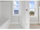 Bright bathroom with a white bathtub, tiled floors and a window with a view to the outside at 305 Lineback Pl. # 33, Longs, SC 29568