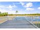 Relaxing deck with white railings overlooking a tranquil lake and lush greenery at 305 Lineback Pl. # 33, Longs, SC 29568
