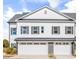 Inviting exterior showcasing a modern two-story townhome with white siding, gray shutters, and individual garages at 305 Lineback Pl. # 33, Longs, SC 29568