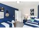 Comfortable bedroom featuring two beds, a navy accent wall and stylish decorations at 324 Mayflower Dr., Calabash, NC 28467