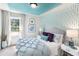 Inviting bedroom with a blue accent wall, a comfortable bed, and ample natural light at 324 Mayflower Dr., Calabash, NC 28467