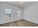 Bright bedroom with wood flooring, ceiling fan, and two windows letting in natural light at 324 Mayflower Dr., Calabash, NC 28467