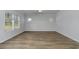 Spacious bedroom with wood flooring, white trim, and multiple windows for ample lighting at 324 Mayflower Dr., Calabash, NC 28467