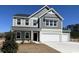 Two-story home with gray siding, white trim, covered porch, and a two car garage at 324 Mayflower Dr., Calabash, NC 28467