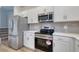 Modern kitchen with stainless steel appliances, gray backsplash, and white cabinetry at 324 Mayflower Dr., Calabash, NC 28467