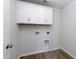 Laundry room with white cabinets above washer/dryer hookups and wood-look flooring at 324 Mayflower Dr., Calabash, NC 28467
