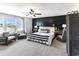 Cozy main bedroom showcasing a dark wood accent wall, neutral furnishings, and ample natural light at 324 Mayflower Dr., Calabash, NC 28467