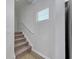 Stairway with carpeted steps and white handrail with a window letting in natural light at 324 Mayflower Dr., Calabash, NC 28467