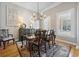 Formal dining area with a wood table set for six, a chandelier, and large windows offering plenty of natural light at 356 Savannah Dr., Pawleys Island, SC 29585