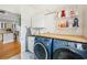 Well-equipped laundry room with front-load washer and dryer, countertop, and storage shelves at 356 Savannah Dr., Pawleys Island, SC 29585