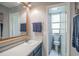 Bathroom with blue cabinets, framed mirror, and well-lit vanity and a toilet behind an open door at 358 Salt Marsh Circle # 10-A, Pawleys Island, SC 29585