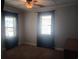 Bedroom featuring neutral walls, carpet, and two bright windows with dark curtains, illuminated by a ceiling fan at 360 South Green Sea Rd., Loris, SC 29569