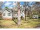 Backyard view showcasing the house's siding, brick foundation, trees, and well-maintained lawn at 3740 Limerick Rd., Myrtle Beach, SC 29579