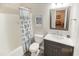 Well-lit bathroom featuring a vanity with marble countertop, modern fixtures, and a shower-tub combo with patterned curtain at 3740 Limerick Rd., Myrtle Beach, SC 29579