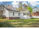 Rear exterior view of home featuring well-maintained siding, brick foundation, sunroom, and spacious backyard at 3740 Limerick Rd., Myrtle Beach, SC 29579