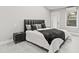 This bedroom boasts minimalist décor with a large upholstered headboard and views from a nearby window at 3806 North Ocean Blvd., Myrtle Beach, SC 29577