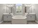 Bright bathroom features dual vanities, garden tub with window, and neutral tones at 4222 Congressional Dr., Myrtle Beach, SC 29579