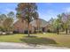 Beautiful brick home featuring a well-manicured lawn, lush trees, and classic architectural details at 4222 Congressional Dr., Myrtle Beach, SC 29579