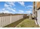 The backyard with white fence, grassy area, and grill at 4305 S Ocean Blvd. # 301, North Myrtle Beach, SC 29582