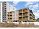 Exterior of multi-story condo building with multiple decks and balconies on a sunny day at 4305 S Ocean Blvd. # 301, North Myrtle Beach, SC 29582
