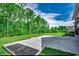 A concrete patio overlooks a spacious, well-manicured backyard with lush green grass and tall trees, perfect for outdoor activities at 4437 Marshwood Dr., Myrtle Beach, SC 29579