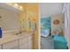 Yellow bathroom offers sink and mirror with a view into the bedroom at 4500 S Ocean Blvd. # 9-B, North Myrtle Beach, SC 29582
