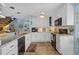 Modern kitchen boasts white cabinets, granite countertops, and stainless steel appliances, seamlessly connecting to the living space at 4500 S Ocean Blvd. # 9-B, North Myrtle Beach, SC 29582