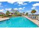 Community pool with ample seating and lounging, palm trees, and view of the waterway at 4652 Lightkeepers Way # 38-C, Little River, SC 29566