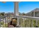 Cozy condo balcony featuring a wicker chair and pillow overlooking the parking area and building at 4709 Wild Iris Dr. # 305, Myrtle Beach, SC 29577
