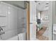 Bathroom with a tub/shower combo, white cabinets, and a glimpse into the bedroom at 4709 Wild Iris Dr. # 305, Myrtle Beach, SC 29577