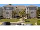 Three-story condo building has balconies and is beautifully landscaped with palm trees and stone at 4709 Wild Iris Dr. # 305, Myrtle Beach, SC 29577