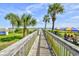 A wooden boardwalk leads to the beach with umbrellas and chairs for guests to relax at 5300 N Ocean Blvd. # 708, Myrtle Beach, SC 29577
