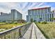 A building's exterior view from a wooden boardwalk with landscaped lawns and palm trees at 5300 N Ocean Blvd. # 708, Myrtle Beach, SC 29577