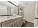 Bathroom with double sinks, large mirror, shelving unit, and a nearby toilet and shower at 5308 N Ocean Blvd. # 503, Myrtle Beach, SC 29577