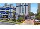 Modern condo building with a gray and white facade, palm trees, and covered parking at 5308 N Ocean Blvd. # 503, Myrtle Beach, SC 29577