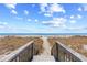 Direct beach access via wooden stairs, providing convenient enjoyment of the sandy shores at 5601 N Ocean Blvd. # C-311, Myrtle Beach, SC 29577