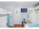 Bedroom with door to laundry, TV on the wall, and view into an adjacent room at 5601 N Ocean Blvd. # C-311, Myrtle Beach, SC 29577