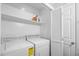 Bright laundry room with washer, dryer, shelving, and a folding door for storage and organization at 600-B 43Rd Ave. S, North Myrtle Beach, SC 29582