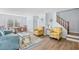 Open-concept living area with laminate floors, comfortable seating, and adjacent dining space and stairs at 600-B 43Rd Ave. S, North Myrtle Beach, SC 29582