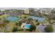 Aerial view featuring several tennis courts, a pool, landscaping and beachside buildings at 77 Tern Pl. # 202, Pawleys Island, SC 29585