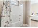 A full bathtub and shower combination is shown with nautical themed curtains in this bathroom at 77 Tern Pl. # 202, Pawleys Island, SC 29585