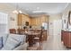 Dining room featuring a modern glass table, seating for six, adjacent to kitchen with wood floors throughout at 77 Tern Pl. # 202, Pawleys Island, SC 29585