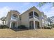 The exterior of this yellow home has large screened porches and small balconies at 77 Tern Pl. # 202, Pawleys Island, SC 29585