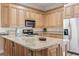 Gourmet kitchen featuring granite counters, stainless appliances, and ample wooden cabinet space, perfect for culinary enthusiasts at 77 Tern Pl. # 202, Pawleys Island, SC 29585