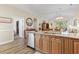 The kitchen sink and island connects to dining room and living room with natural light and stainless steel dishwasher at 77 Tern Pl. # 202, Pawleys Island, SC 29585