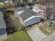 Aerial shot of a home with a protective tarp on the roof, surrounded by mature trees and greenery at 909 Pine Thicket St., Myrtle Beach, SC 29577